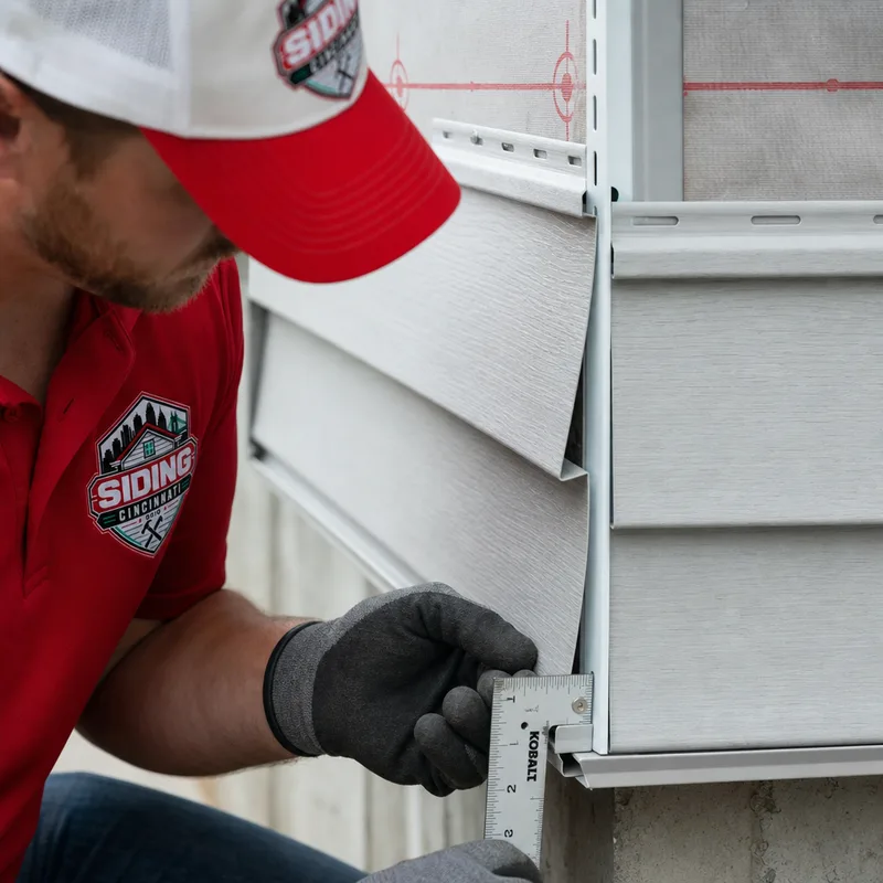 Technician checking fastener spacing, J-channel, flashing, and a properly lapped siding corner seam