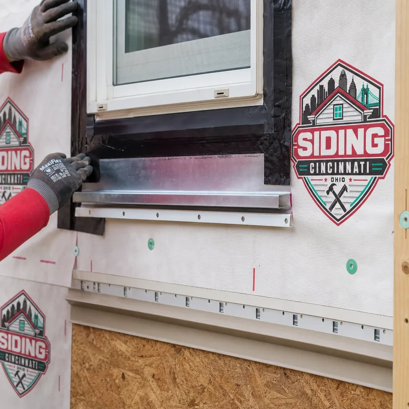 Close-up of properly lapped housewrap, window flashing tape, and metal Z-flashing prepared before new siding installation